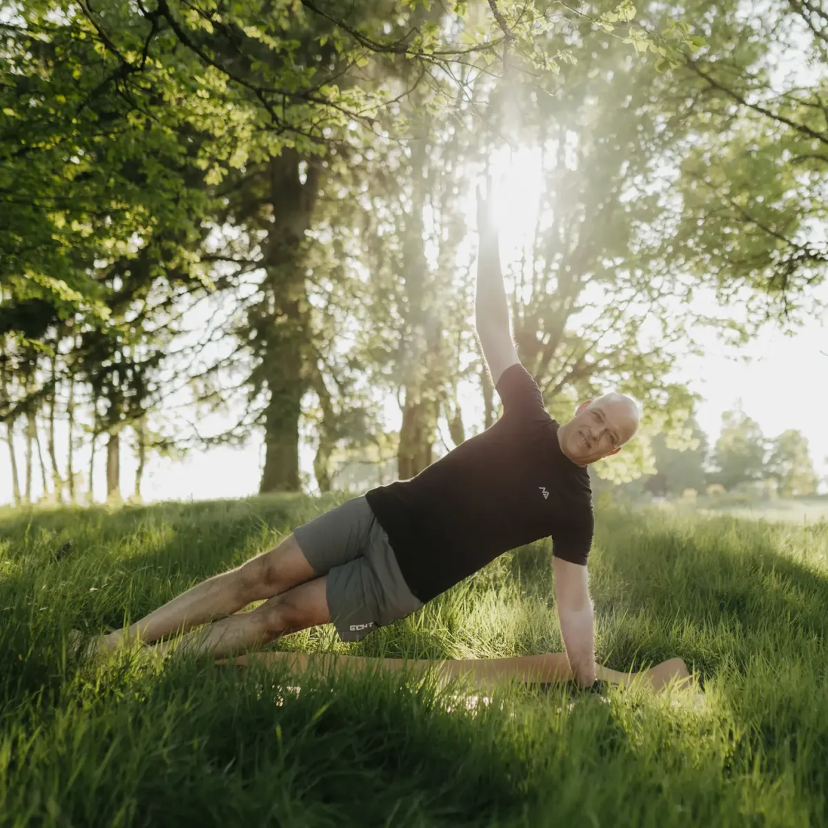 Mann macht Yoga auf einer Wiese