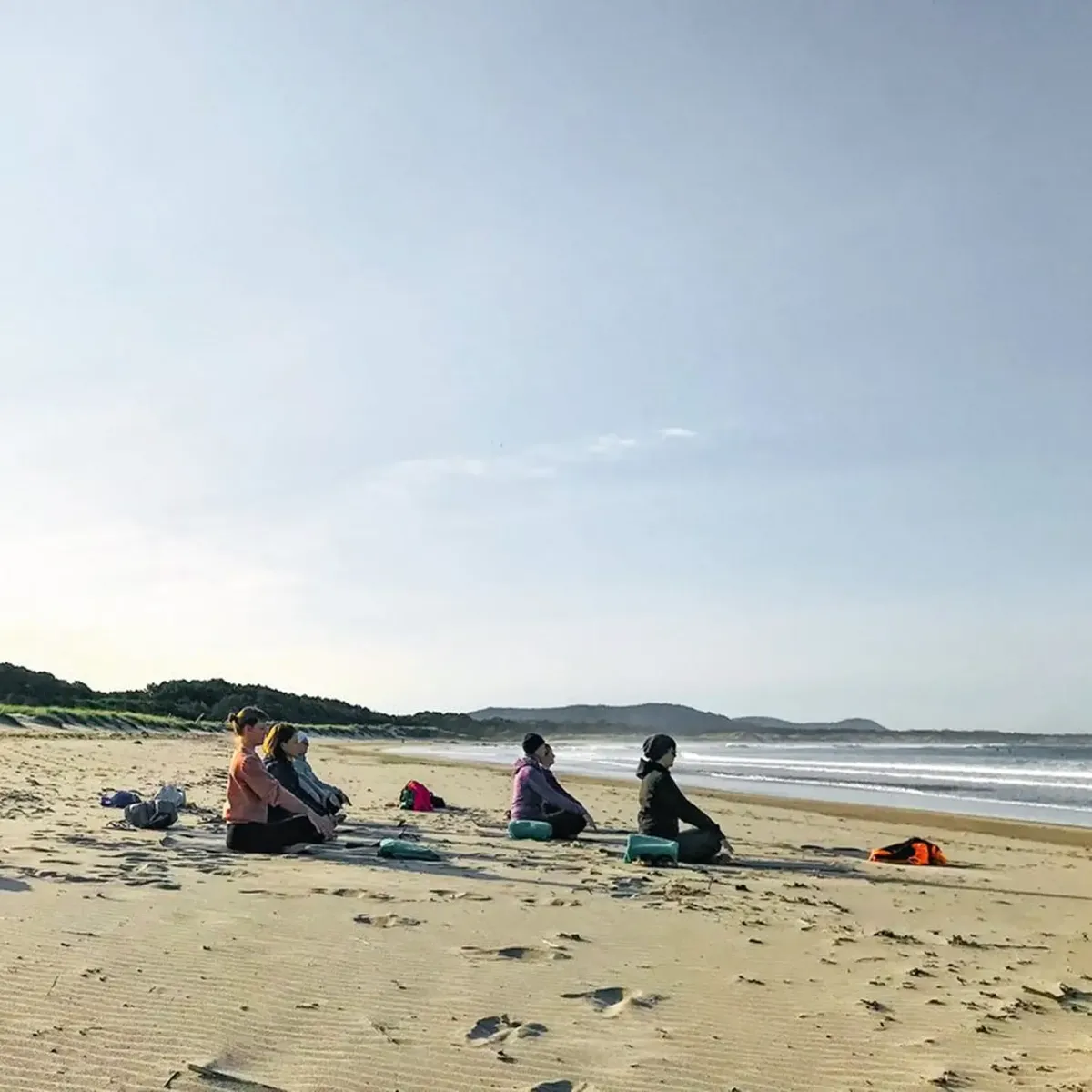 Gruppe macht Yoga am Strand