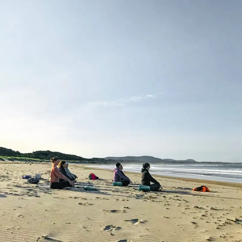 Gruppe macht Yoga am Strand